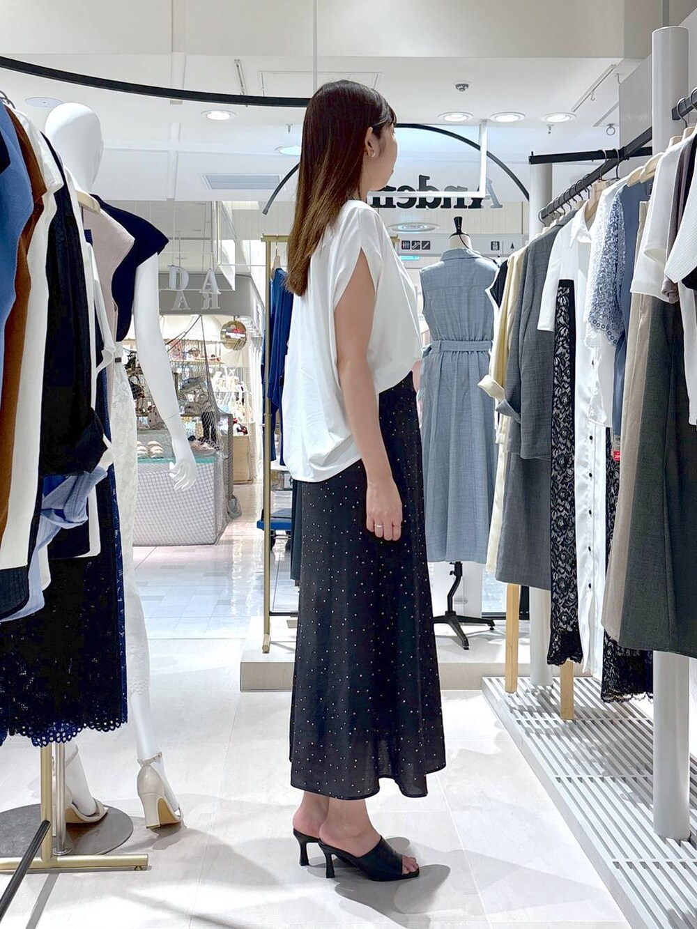 ブラック系のサンダル、ベージュ系のショルダーバッグ、ブラック系のスカートを着用したレディースの夏コーディネートの4枚目の写真