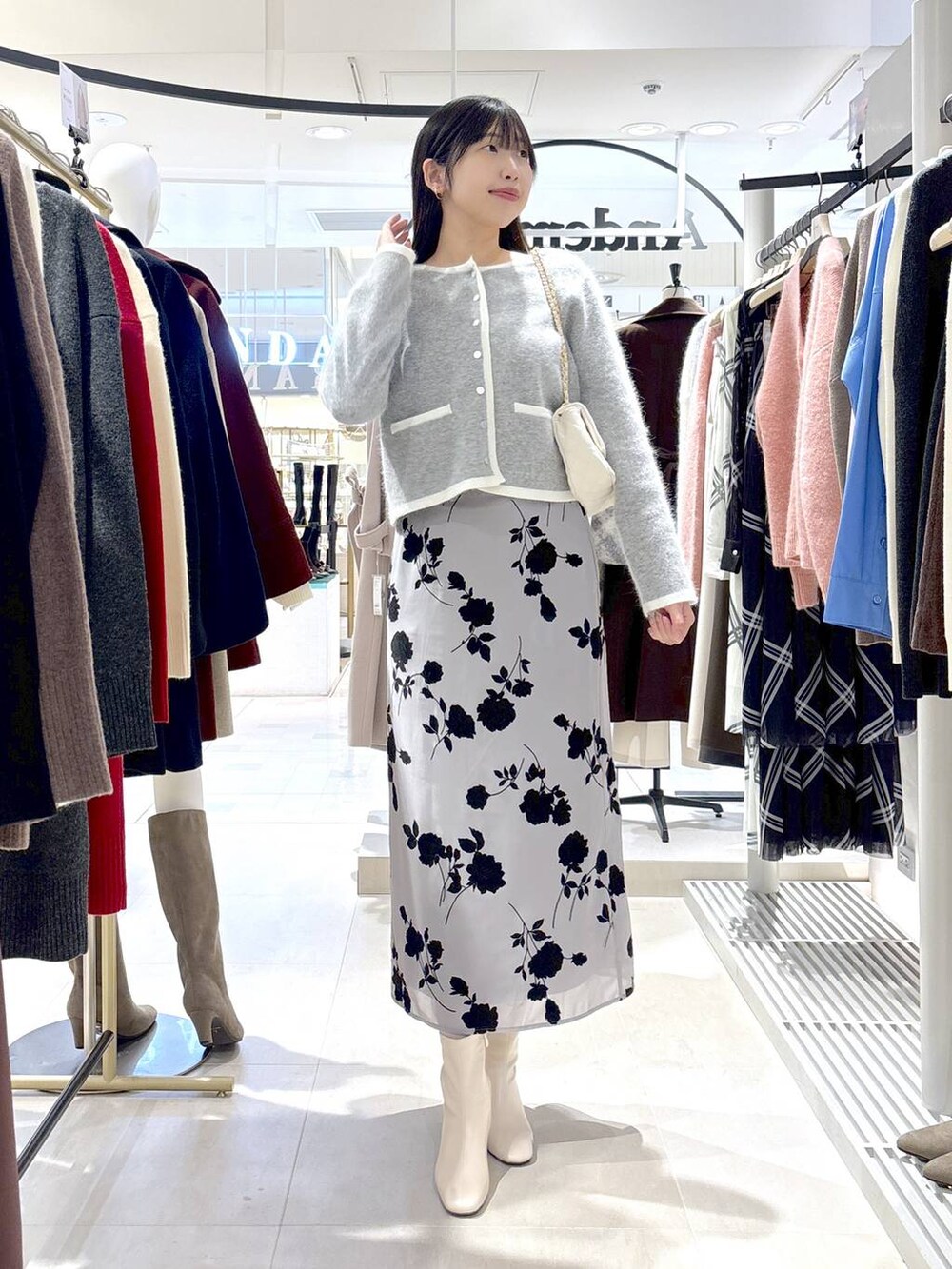 グレー系のカーディガン/ボレロ、ホワイト系のブーツ、ホワイト系のショルダーバッグを着用したレディースの秋コーディネートの2枚目の写真