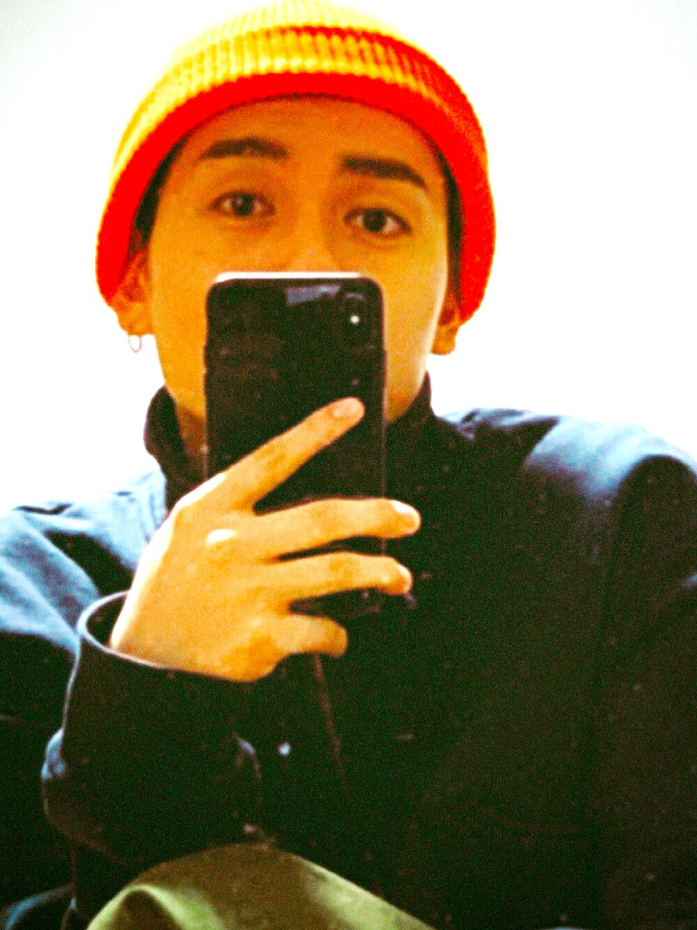 オレンジ系のニットキャップ/ビーニーを着用したメンズの冬コーディネートの2枚目の写真