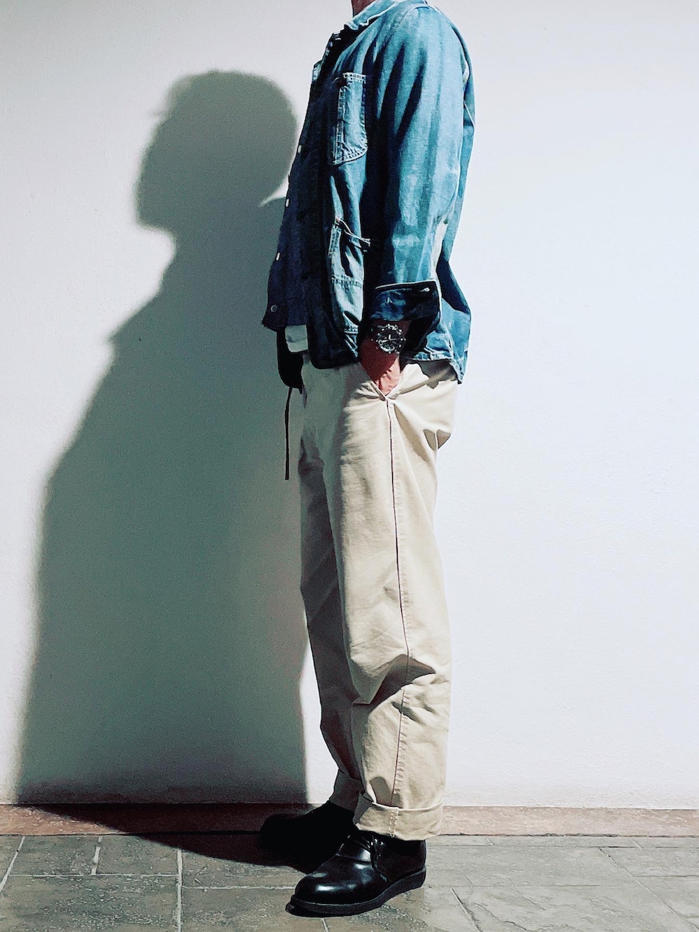 ベージュ系のチノパンツ、ブラック系のブーツ、ブルー系のデニムジャケットを着用したメンズの秋コーディネートの2枚目の写真