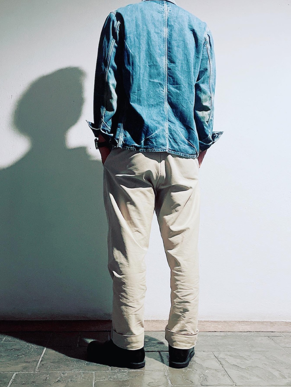 ベージュ系のチノパンツ、ブラック系のブーツ、ブルー系のデニムジャケットを着用したメンズの秋コーディネートの3枚目の写真