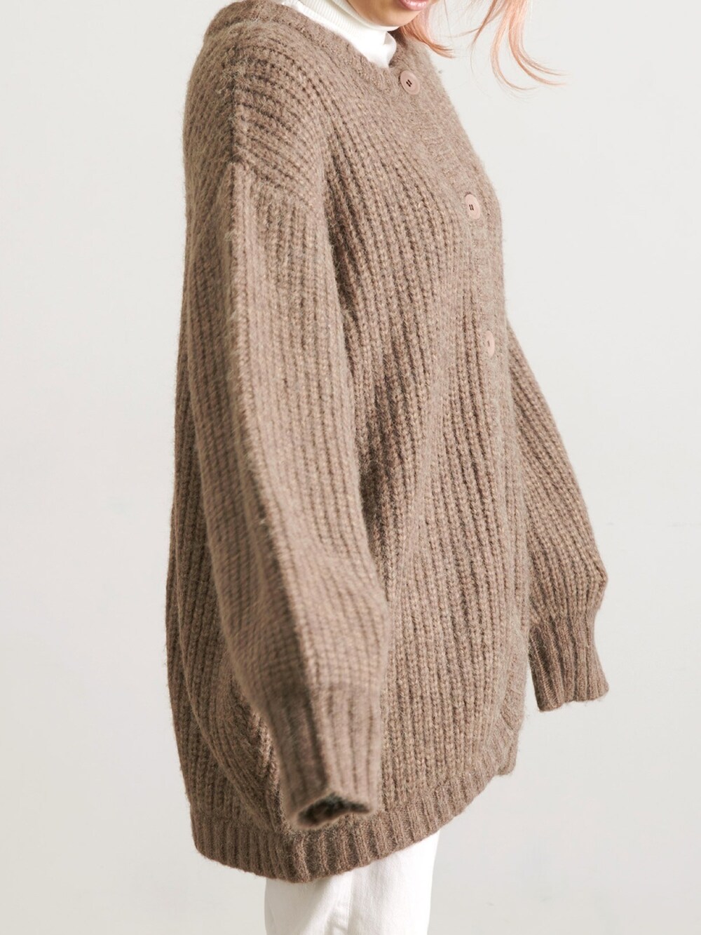 グリーン系のスニーカー、ブラック系のスカート、ホワイト系のカーディガン/ボレロを着用したレディースの秋コーディネートの2枚目の写真