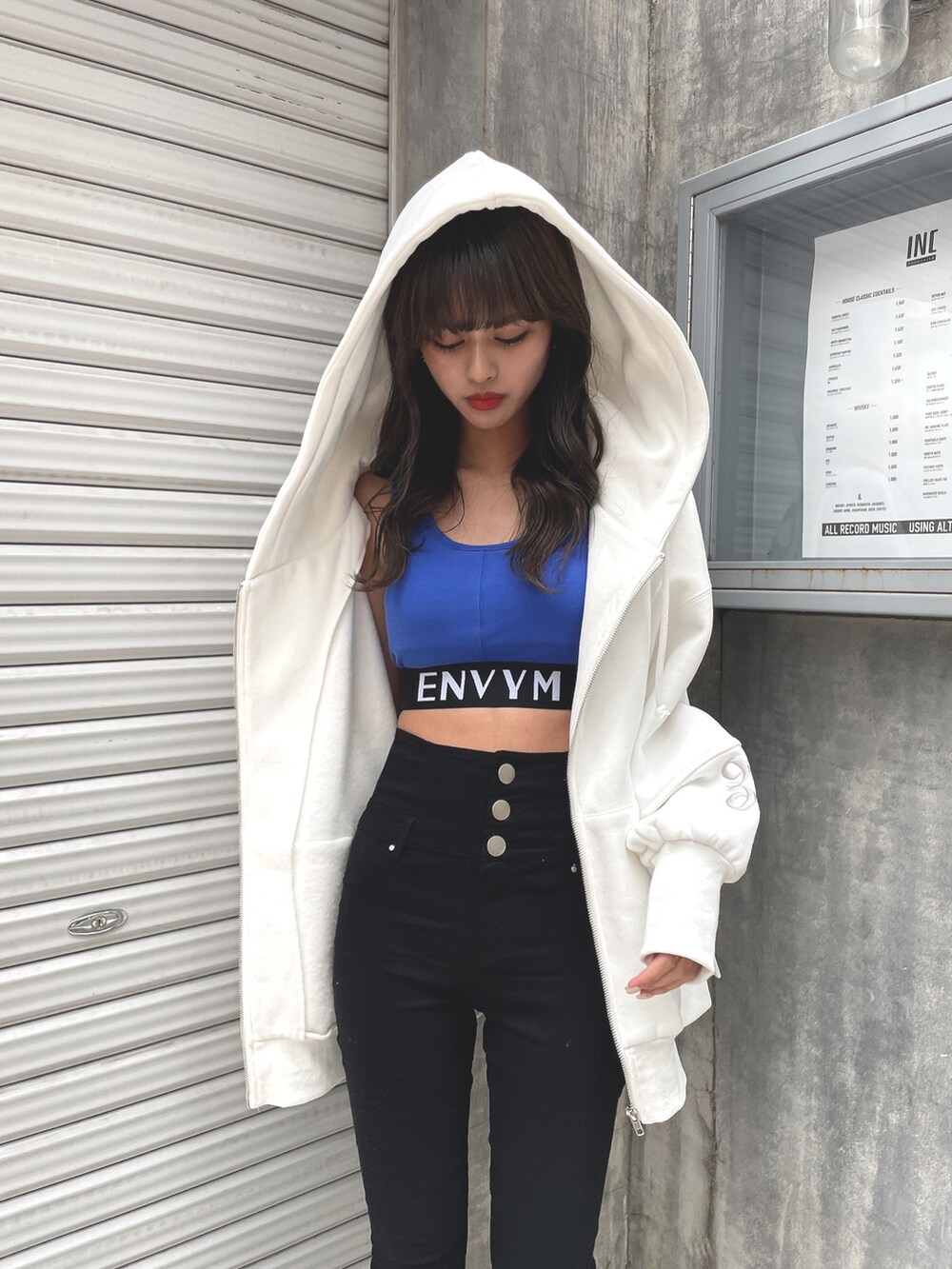 ホワイト系のパーカー、ブルー系のタンクトップ、ブラック系のその他パンツを着用したレディースの春コーディネートの3枚目の写真