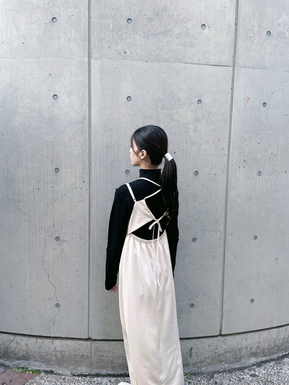 ベージュ系のワンピース、ホワイト系のブーツ、ブラック系のニット/セーターを着用したレディースの冬コーディネートの4枚目の写真