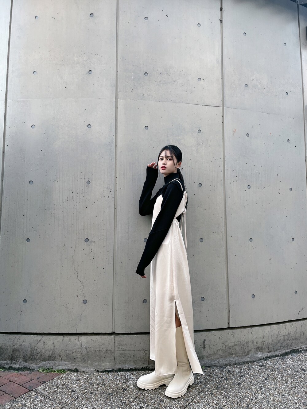 ベージュ系のワンピース、ホワイト系のブーツ、ブラック系のニット/セーターを着用したレディースの冬コーディネートの3枚目の写真