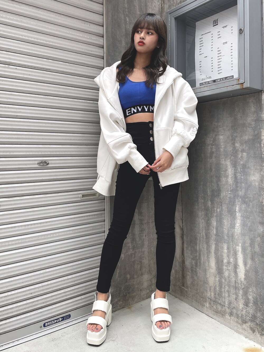 ホワイト系のパーカー、ブルー系のタンクトップ、ブラック系のその他パンツを着用したレディースの春コーディネートの2枚目の写真