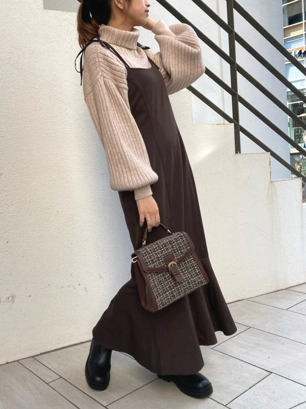 ブラック系のブーツ、ブラウン系のワンピースを着用したレディースの冬コーディネートの2枚目の写真