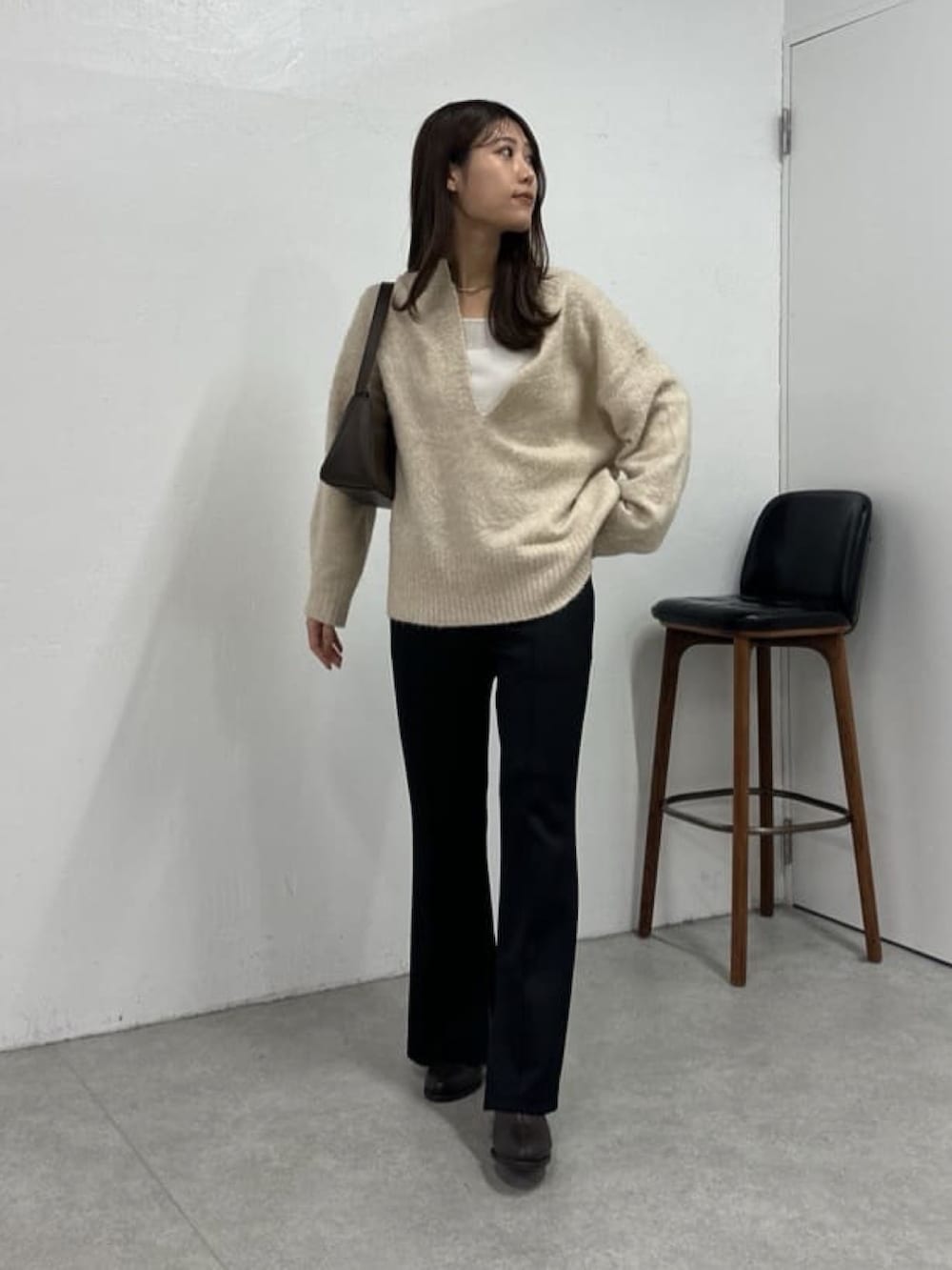 ベージュ系のニット/セーター、ブラック系のその他パンツ、ブラウン系のブーツを着用したレディースの冬コーディネートの2枚目の写真