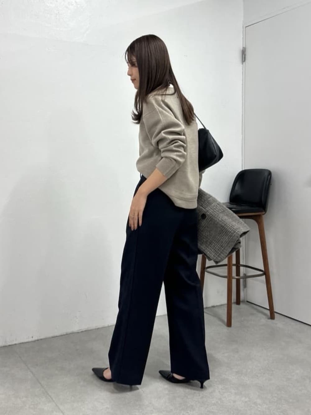 ベージュ系のニット/セーター、ブルー系のスラックス、ブラック系のパンプスを着用したレディースの冬コーディネートの2枚目の写真