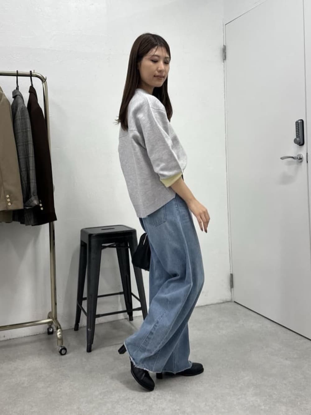 ブルー系のデニムパンツ、グレー系のニット/セーター、ブラック系のボストンバッグを着用したレディースの冬コーディネートの4枚目の写真