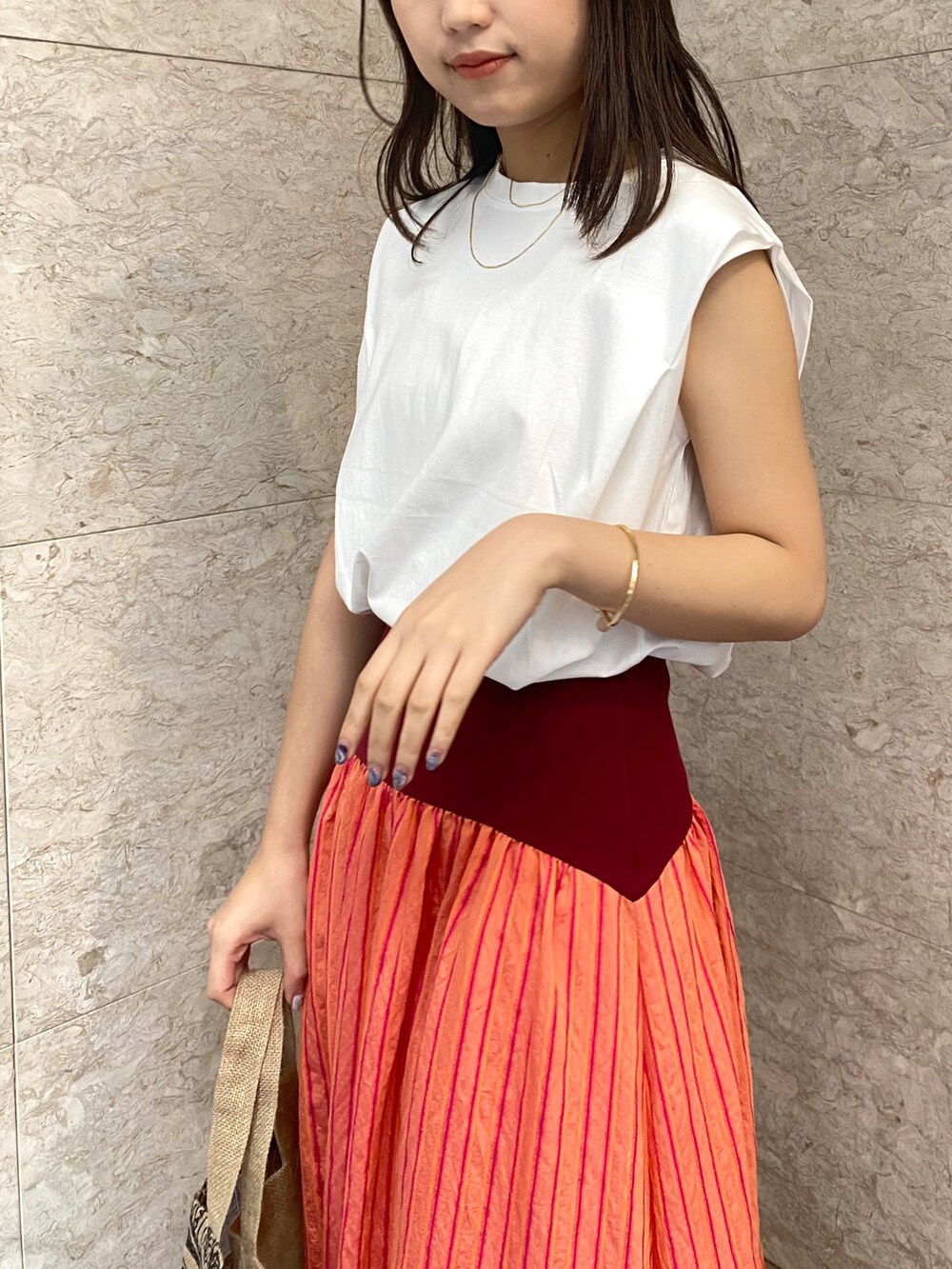 ホワイト系のTシャツ/カットソー、レッド系のスカート、ホワイト系のその他シューズを着用したレディースの春コーディネートの3枚目の写真