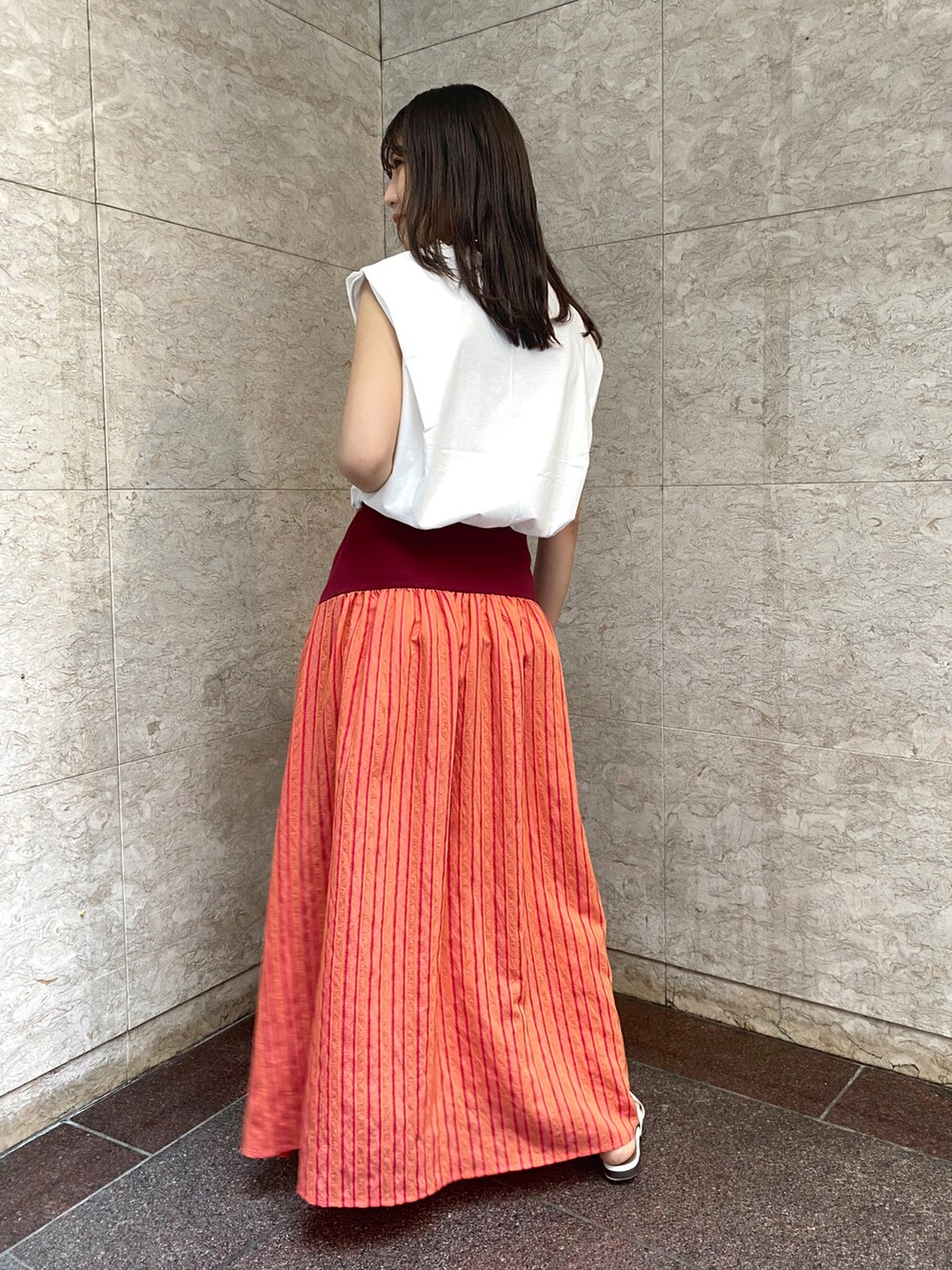 ホワイト系のTシャツ/カットソー、レッド系のスカート、ホワイト系のその他シューズを着用したレディースの春コーディネートの2枚目の写真