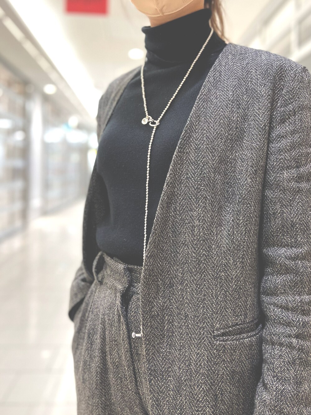 グレー系のセットアップ、グレー系のその他パンツ、ブラック系のニット/セーターを着用したレディースの冬コーディネートの2枚目の写真