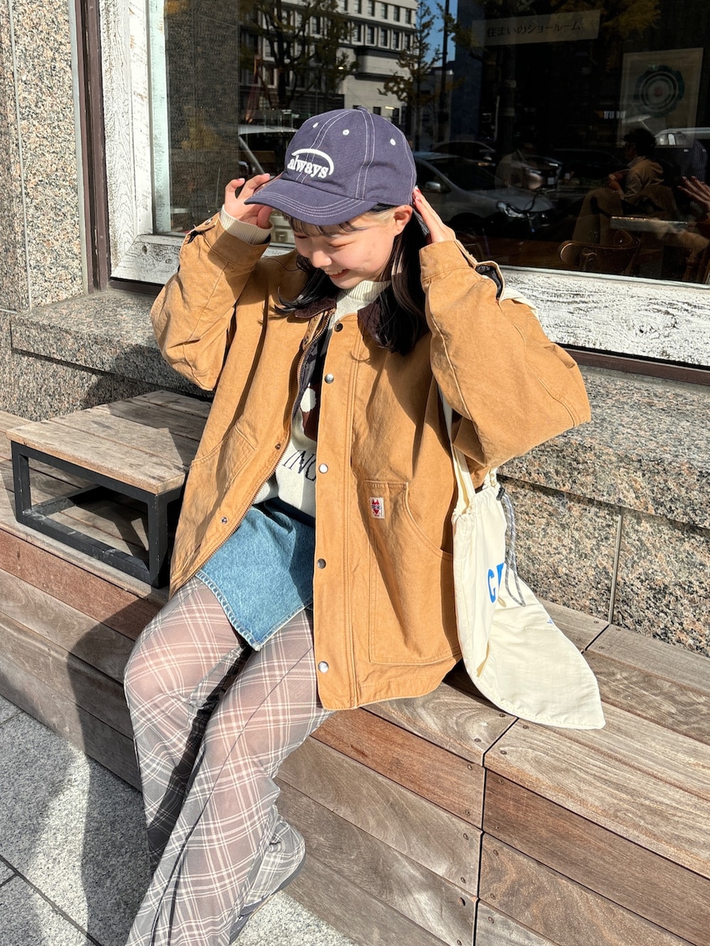 イエロー系のブルゾン、ホワイト系のトートバッグ、ホワイト系のニット/セーターを着用したレディースの冬コーディネートの2枚目の写真