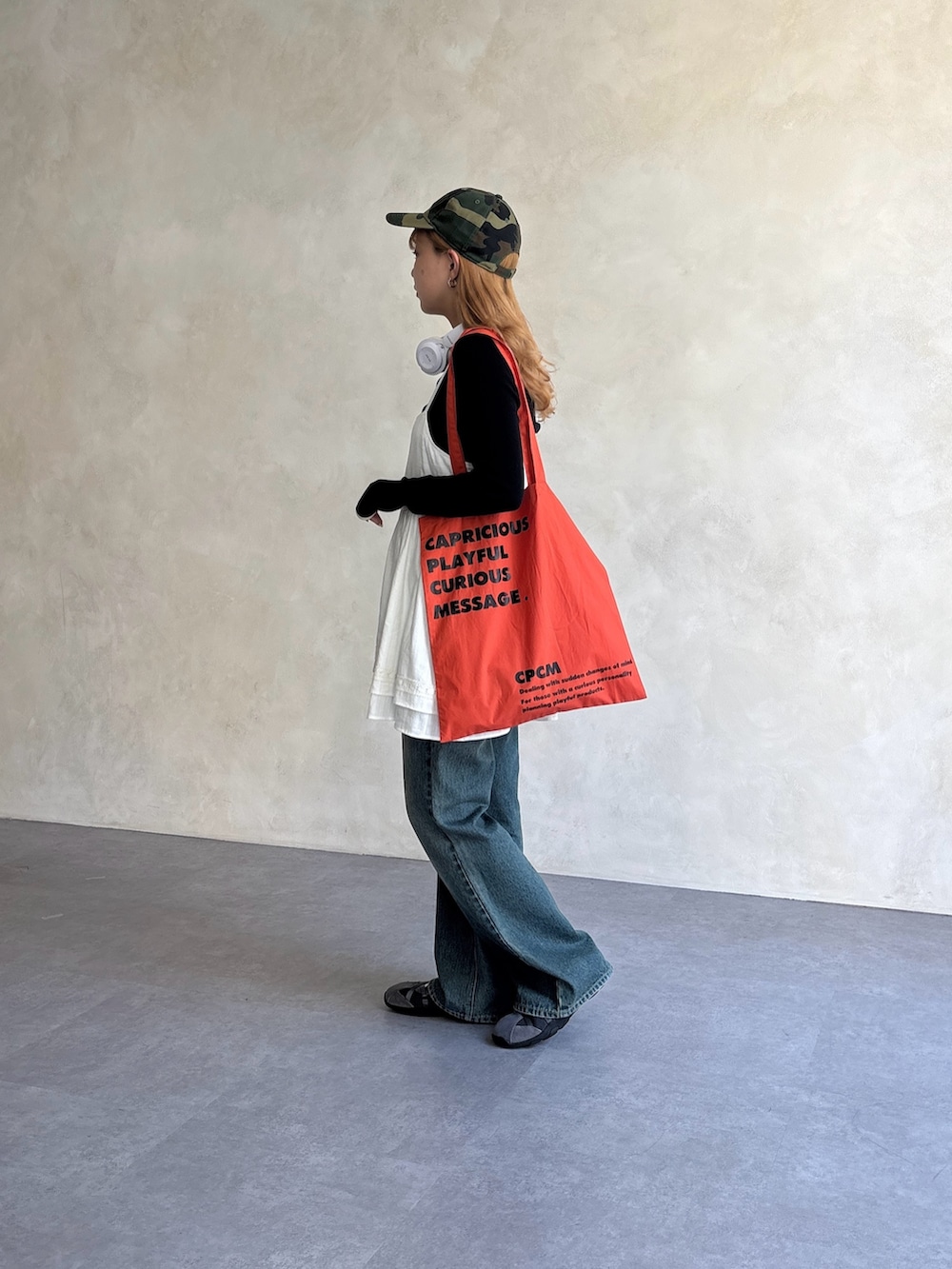 ホワイト系のワンピース、ブルー系のデニムパンツ、ブラック系のTシャツ/カットソーを着用したレディースの夏コーディネートの2枚目の写真