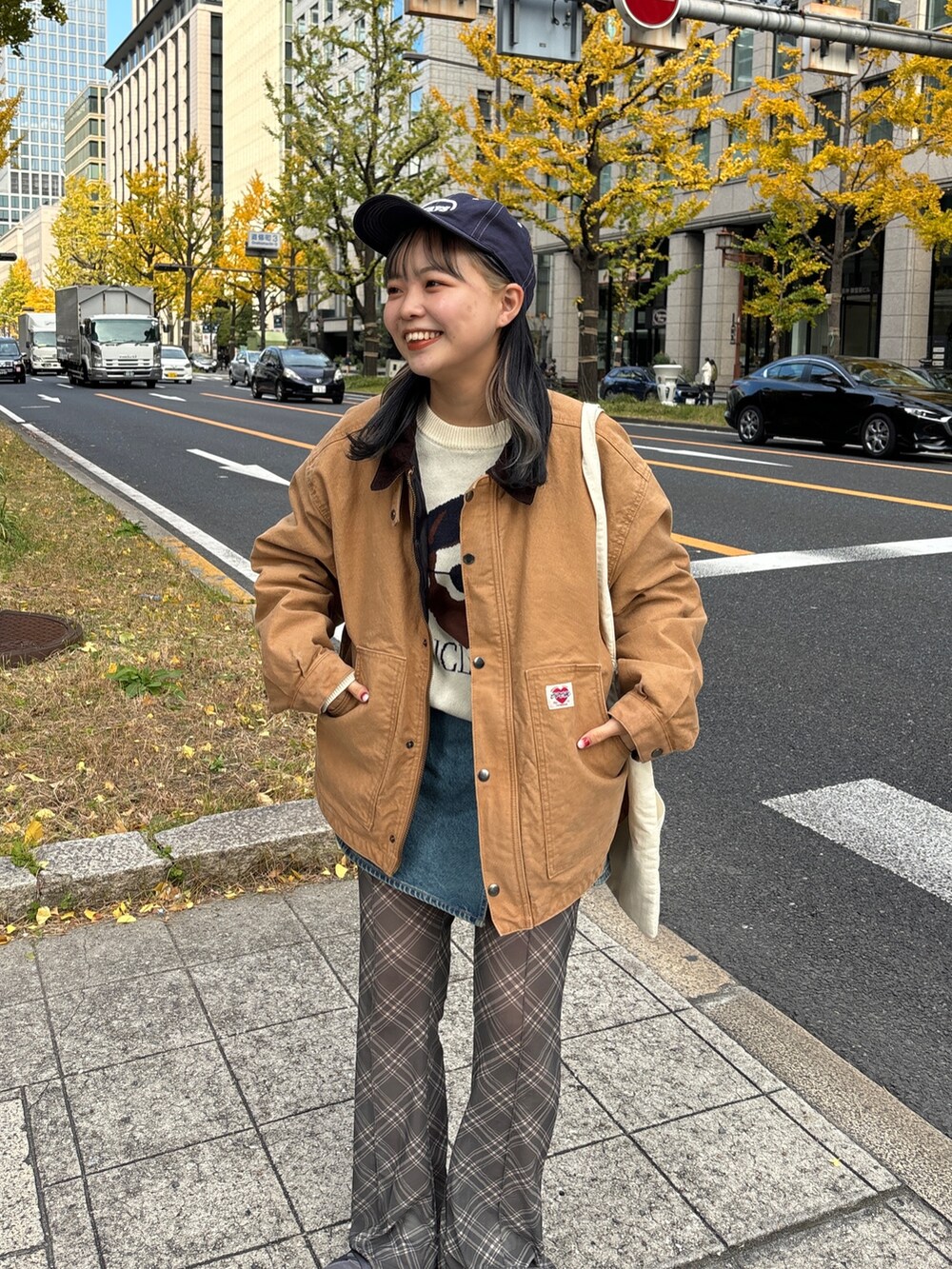 イエロー系のブルゾン、ホワイト系のトートバッグ、ホワイト系のニット/セーターを着用したレディースの冬コーディネートの3枚目の写真