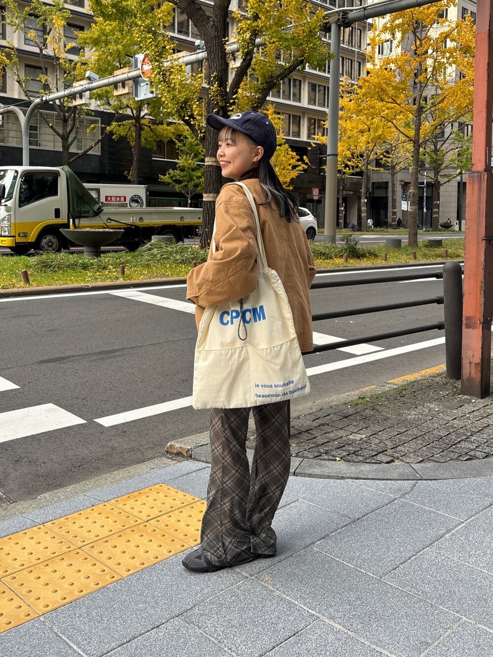 イエロー系のブルゾン、ホワイト系のトートバッグ、ホワイト系のニット/セーターを着用したレディースの冬コーディネートの4枚目の写真