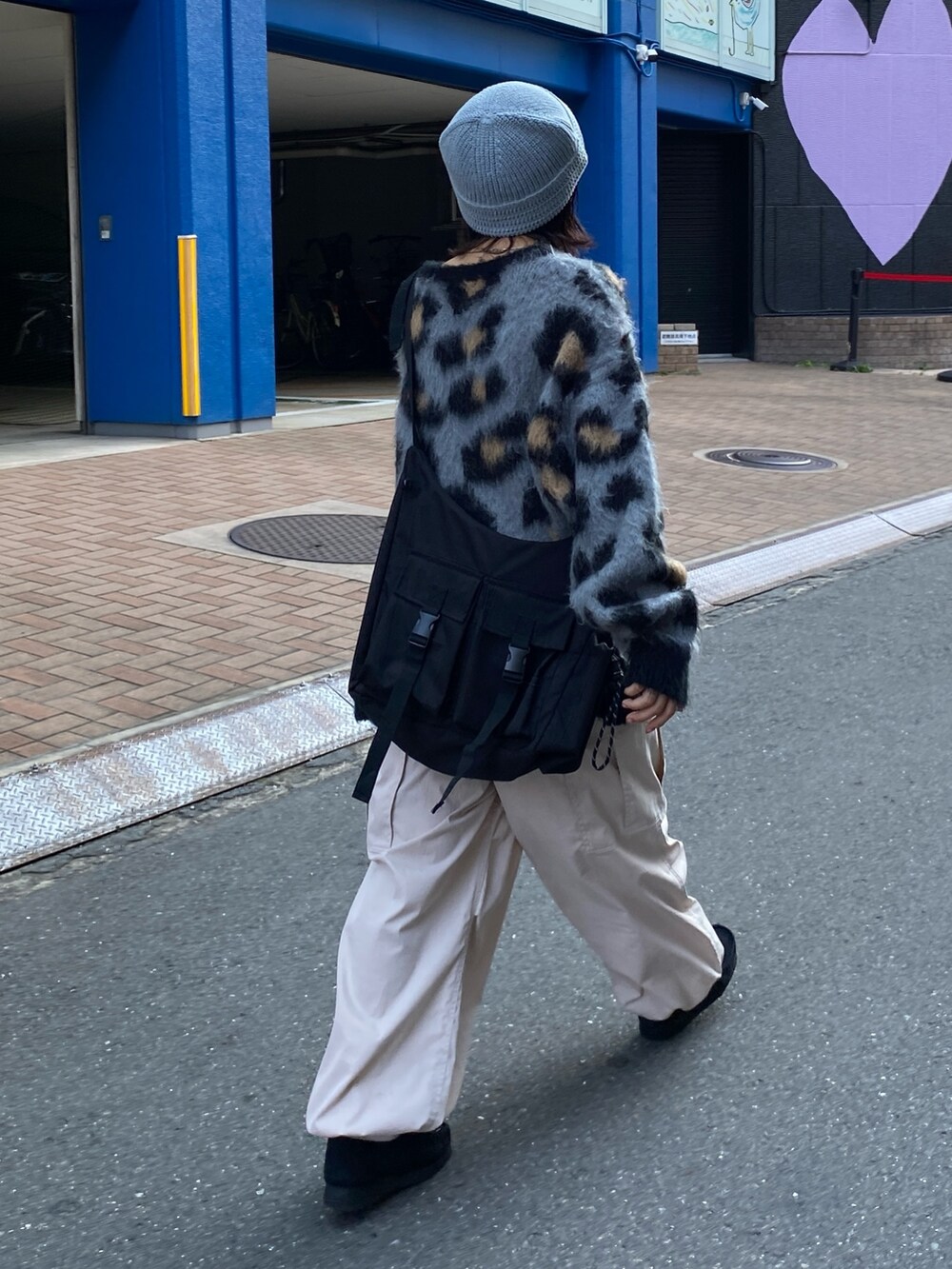 グレー系のニット/セーター、ホワイト系のカーゴパンツ、ブラック系のショルダーバッグを着用したレディースの秋コーディネートの2枚目の写真