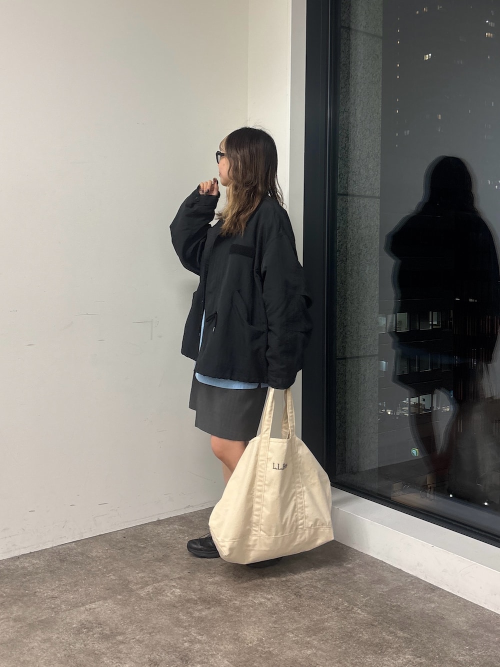 ブラック系のブルゾン、グレー系のその他パンツ、ブルー系のシャツ/ブラウスを着用したレディースの春コーディネートの2枚目の写真