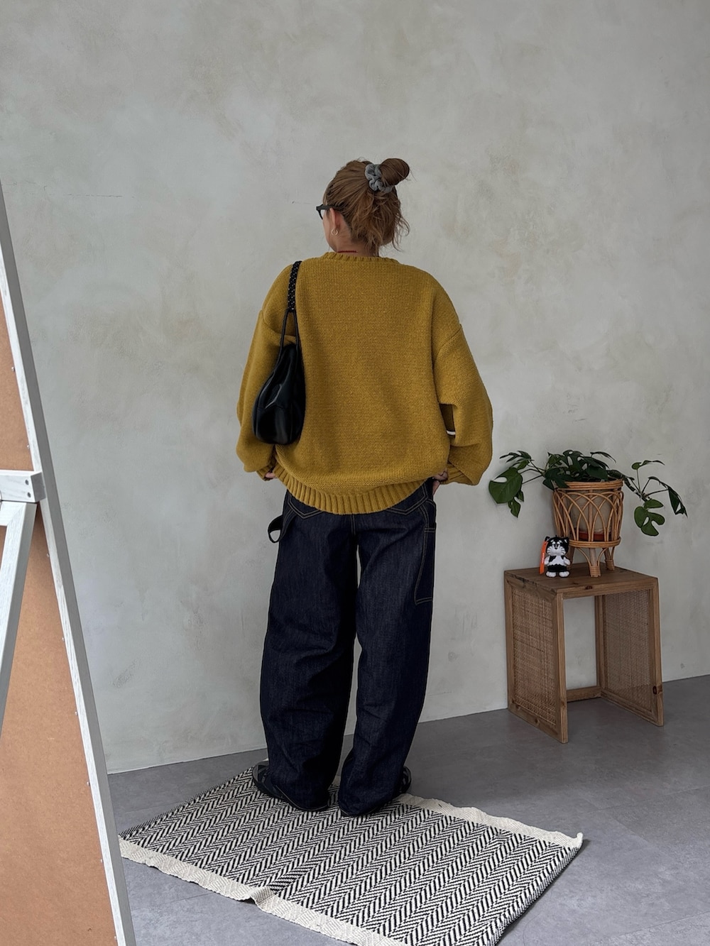 イエロー系のニット/セーター、ブルー系のデニムパンツを着用したレディースの冬コーディネートの3枚目の写真