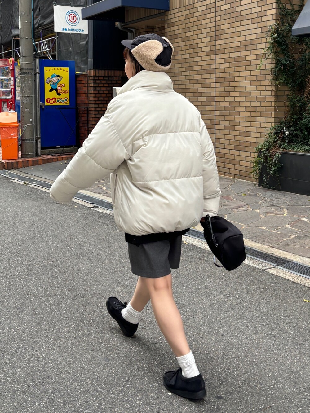 ホワイト系のブルゾン、グレー系のその他パンツ、ブラック系のキャップを着用したレディースの秋コーディネートの2枚目の写真