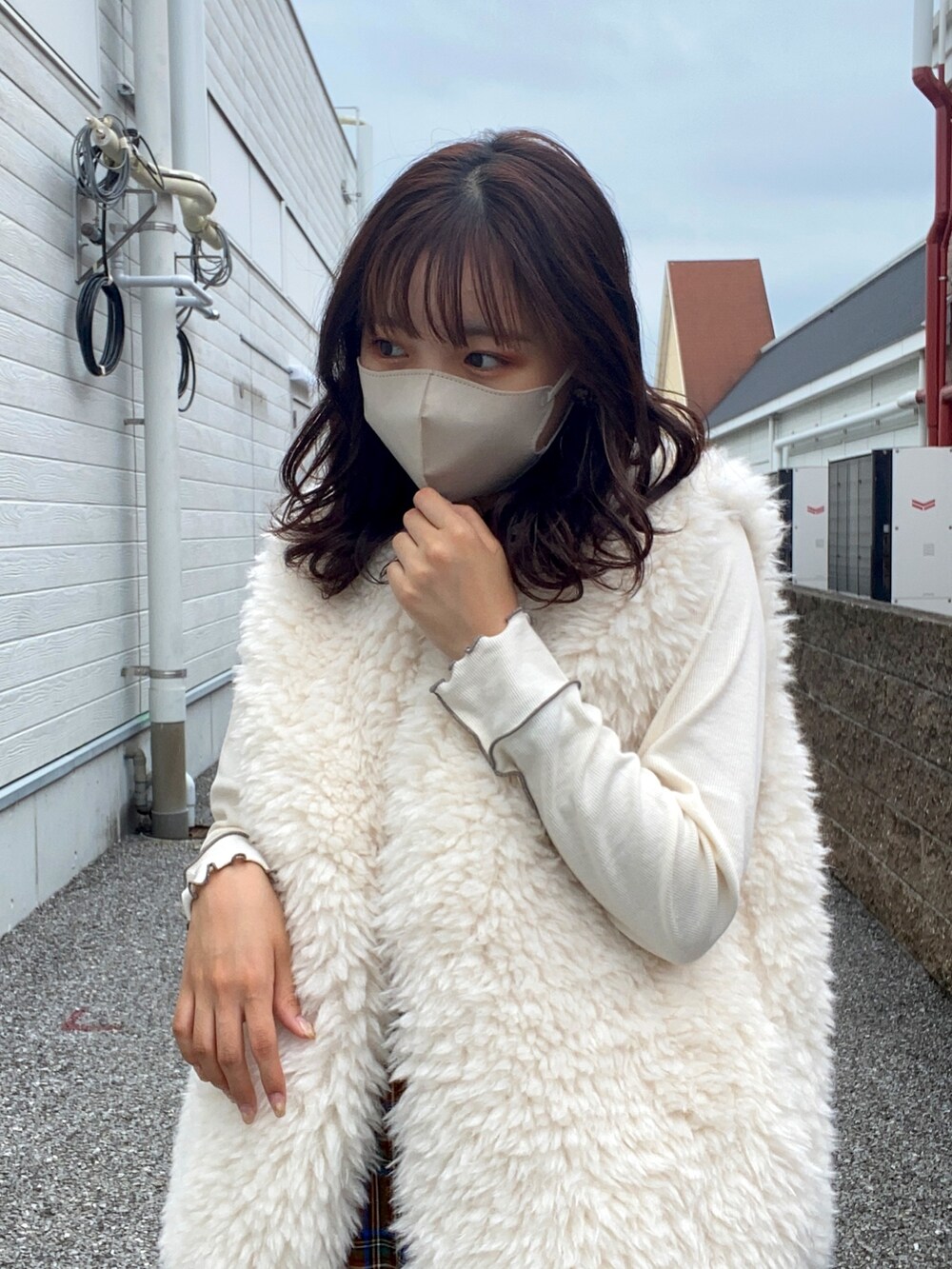 ホワイト系のベスト、ホワイト系のTシャツ/カットソー、イエロー系のスカートを着用したレディースの秋コーディネートの3枚目の写真