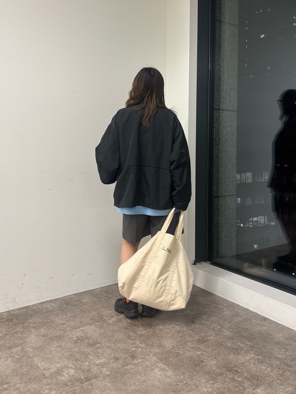 ブラック系のブルゾン、グレー系のその他パンツ、ブルー系のシャツ/ブラウスを着用したレディースの春コーディネートの3枚目の写真