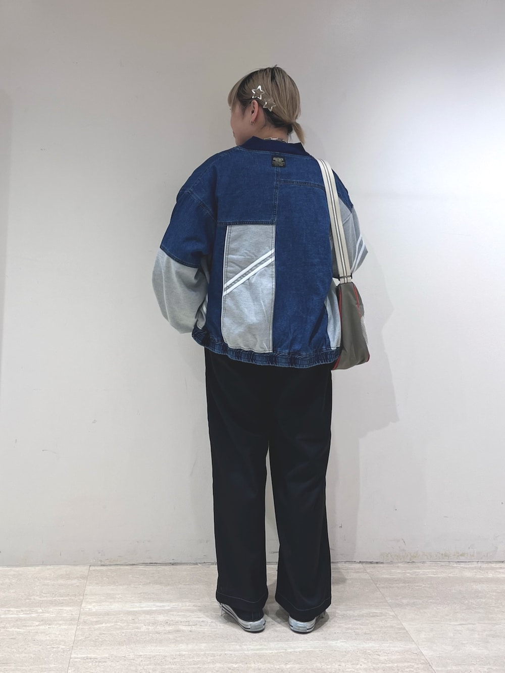 ブルー系のデニムジャケット、グリーン系のショルダーバッグ、ブラック系のその他パンツを着用したレディースの冬コーディネートの3枚目の写真