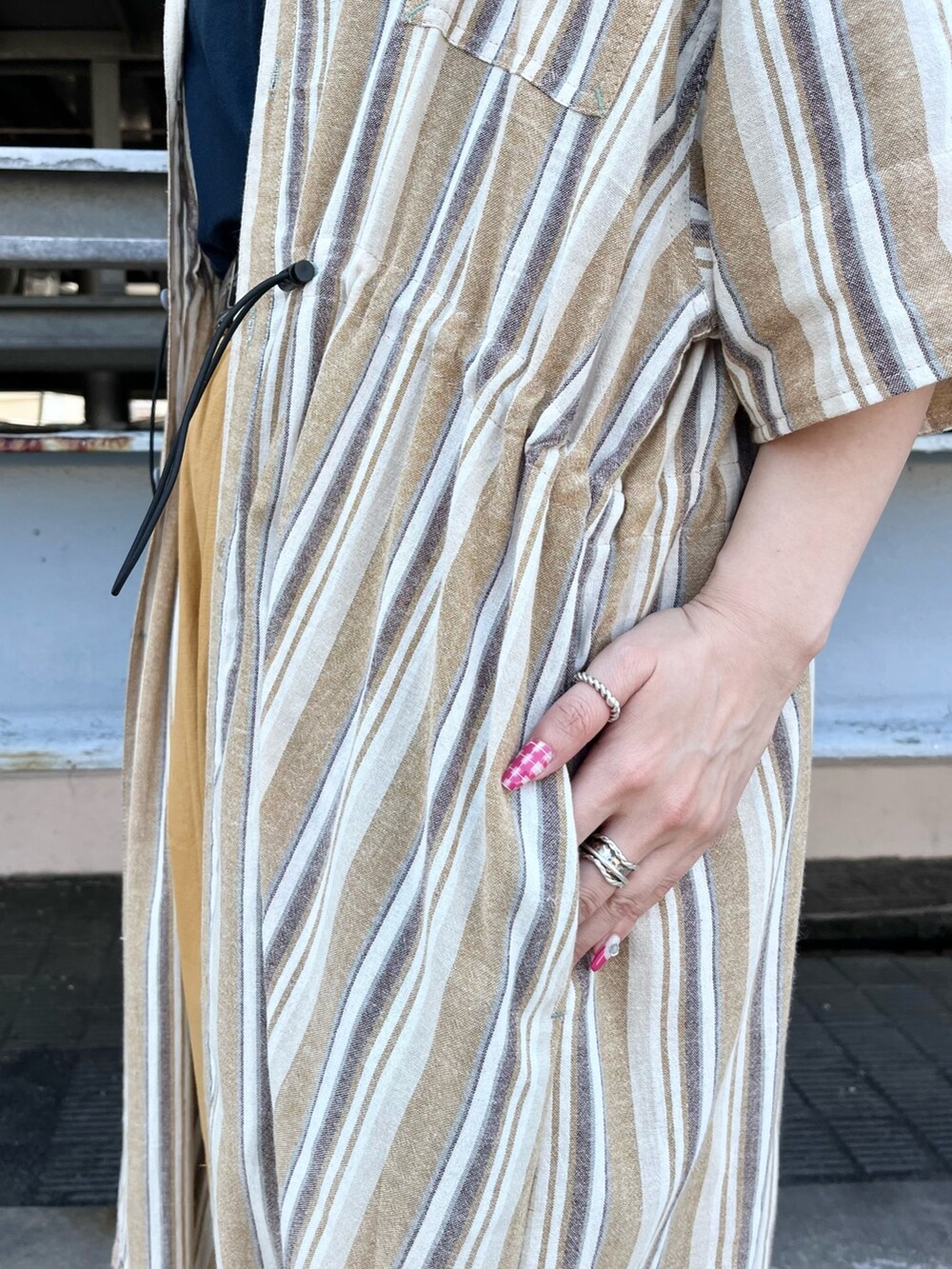 イエロー系のシャツワンピース、ブルー系のTシャツ/カットソー、イエロー系のその他パンツを着用したレディースの春コーディネートの4枚目の写真