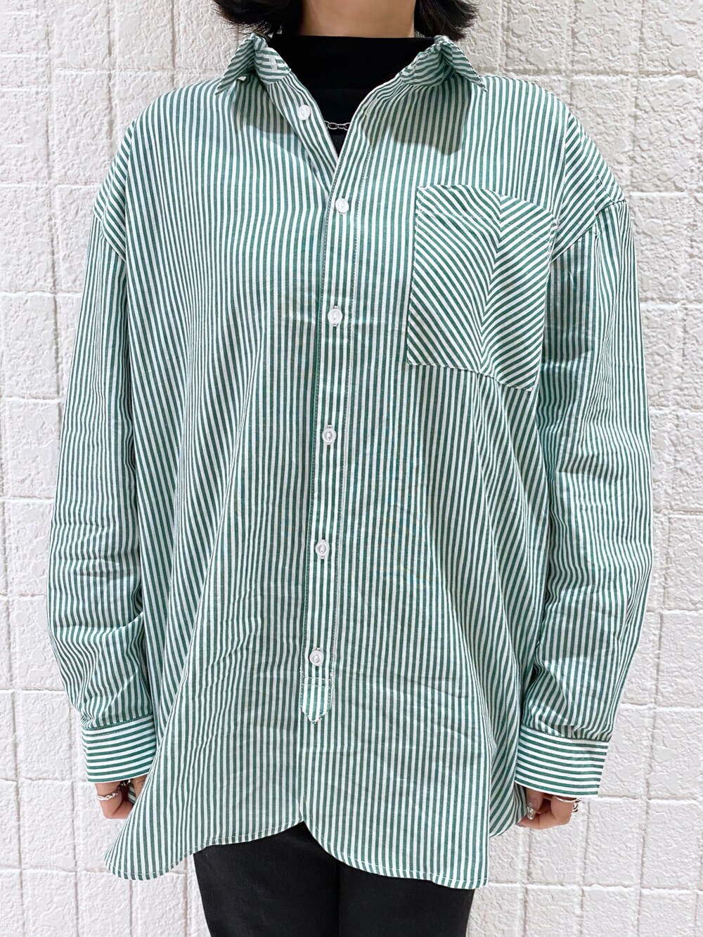 グリーン系のシャツ/ブラウス、ブラック系のTシャツ/カットソー、ブラック系のデニムパンツを着用したレディースの冬コーディネートの3枚目の写真