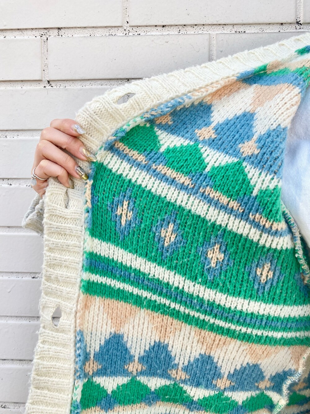 ブラック系のデニムパンツ、ホワイト系のニット/セーター、ホワイト系のスウェットを着用したレディースの冬コーディネートの4枚目の写真