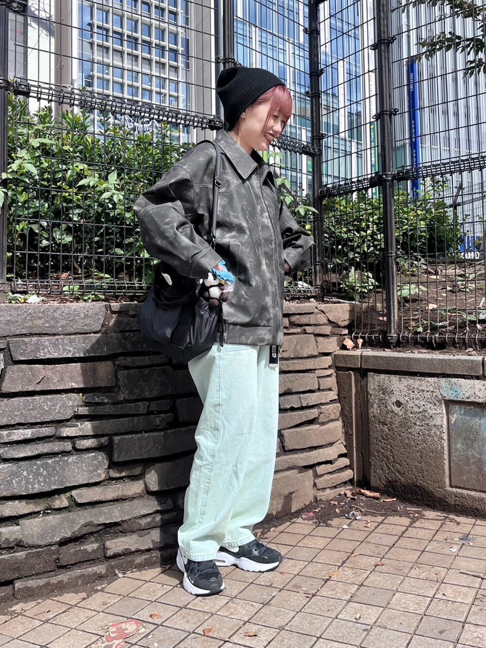 ブラック系のブルゾン、ホワイト系のTシャツ/カットソー、ブルー系のデニムパンツを着用したレディースの秋コーディネートの2枚目の写真