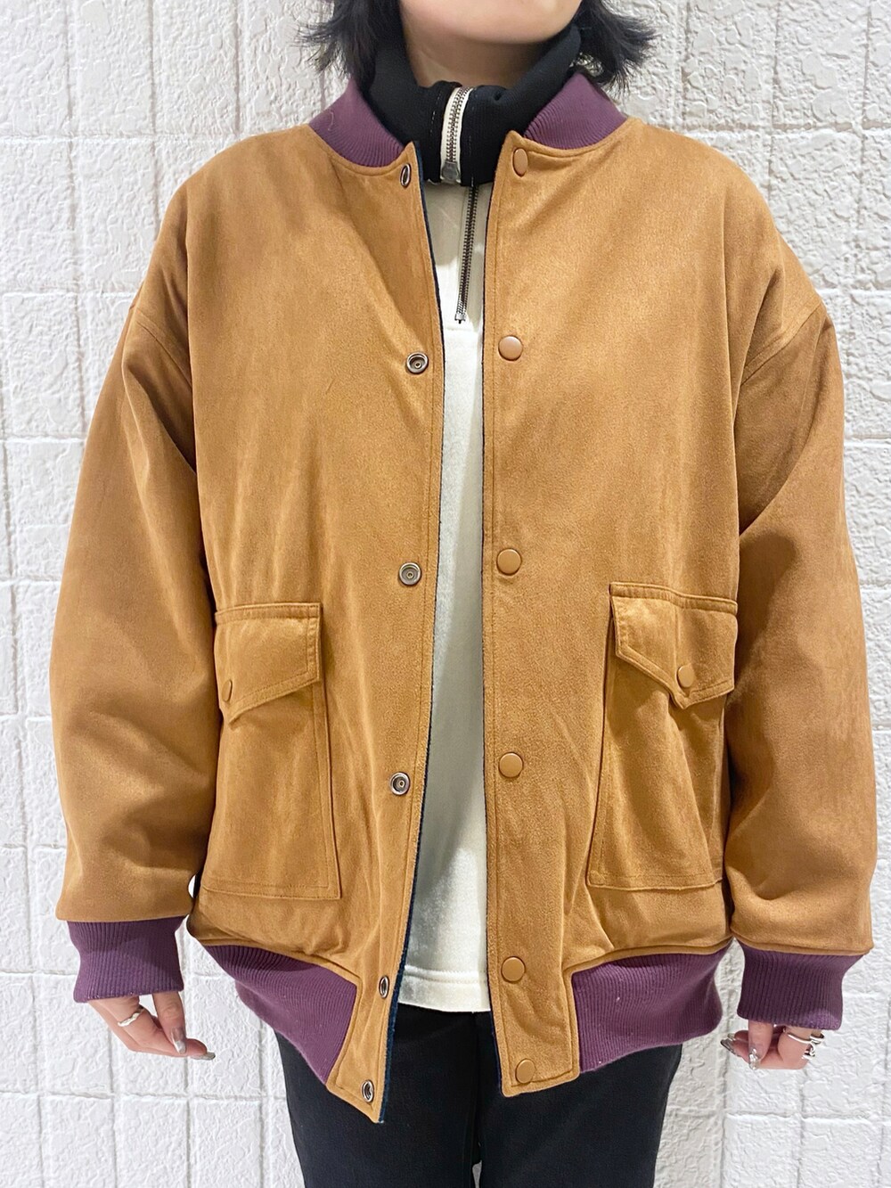 ブルー系のブルゾン、ブラック系のデニムパンツ、ブラック系のスニーカーを着用したレディースの冬コーディネートの4枚目の写真