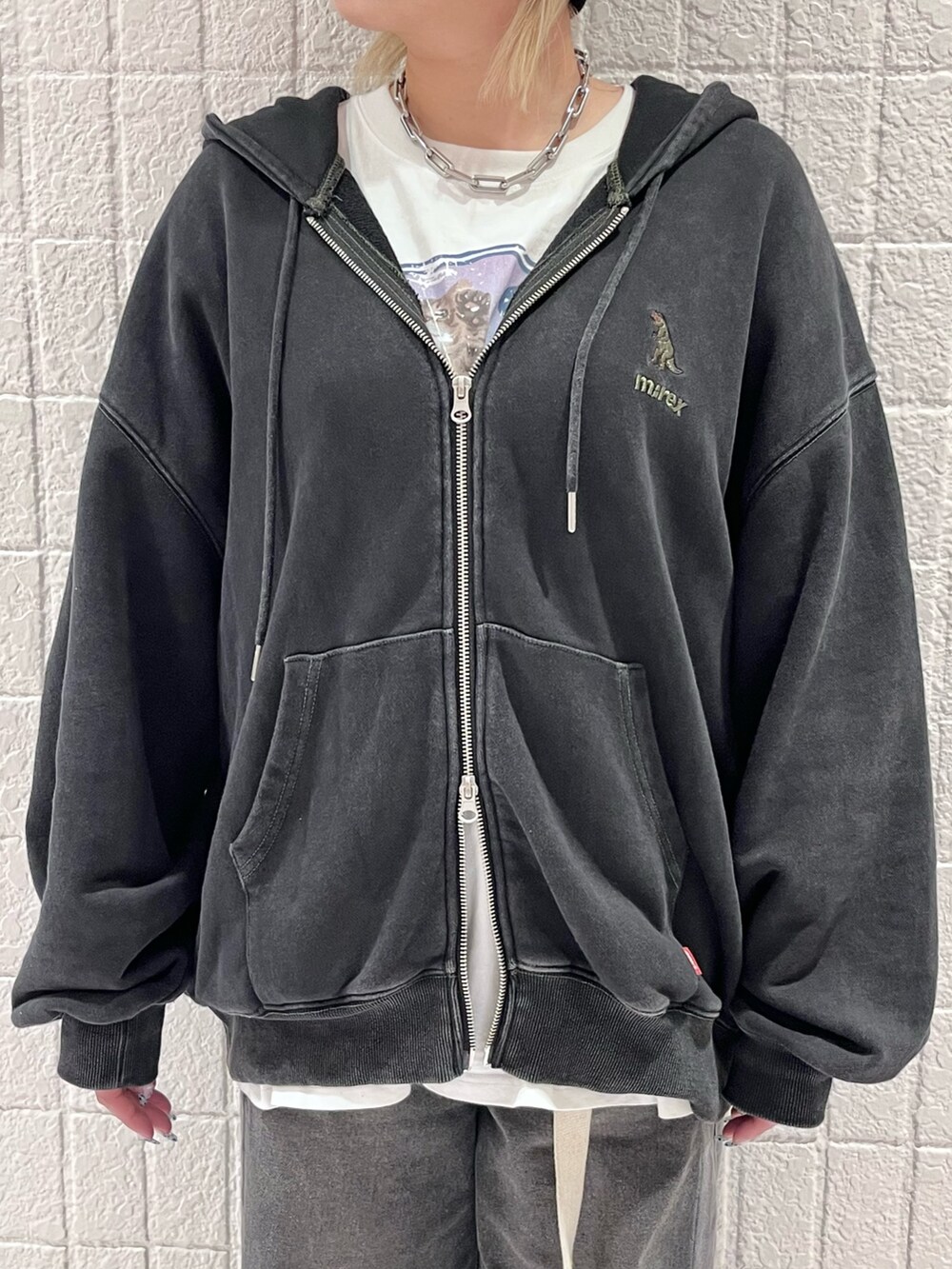 ブラック系のパーカー、ブラック系のデニムパンツ、ホワイト系のベルトを着用したレディースの秋コーディネートの4枚目の写真