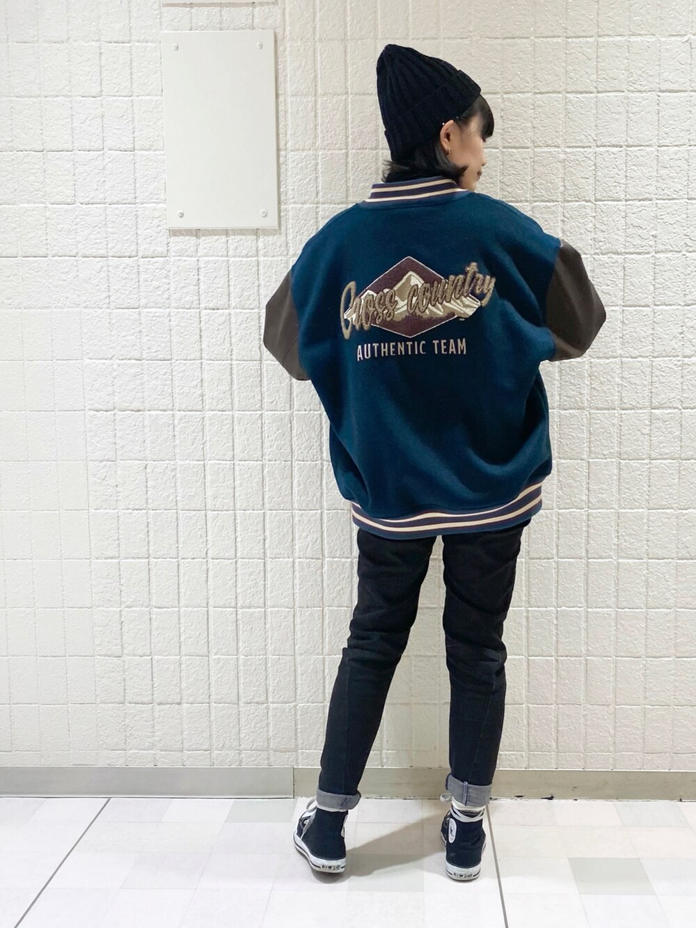 ブルー系のブルゾン、ブラック系のデニムパンツ、ブラック系のスニーカーを着用したレディースの冬コーディネートの3枚目の写真