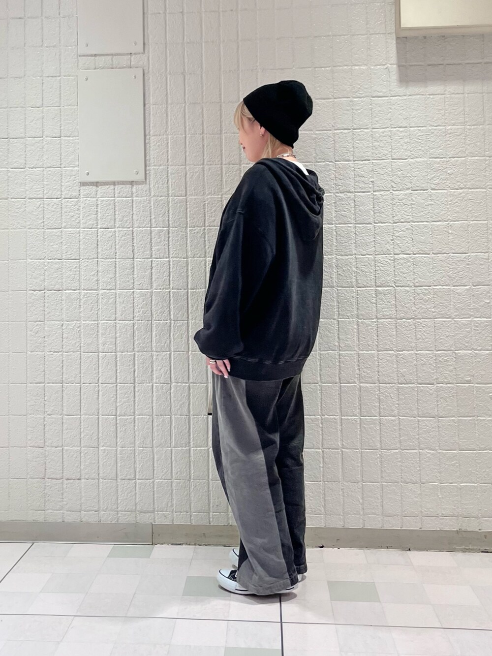 ブラック系のパーカー、ブラック系のデニムパンツ、ホワイト系のベルトを着用したレディースの秋コーディネートの2枚目の写真