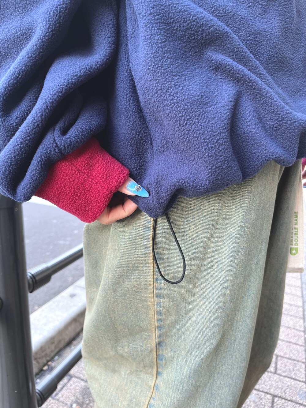 ブルー系のスウェット、グリーン系のデニムパンツを着用したレディースの冬コーディネートの3枚目の写真