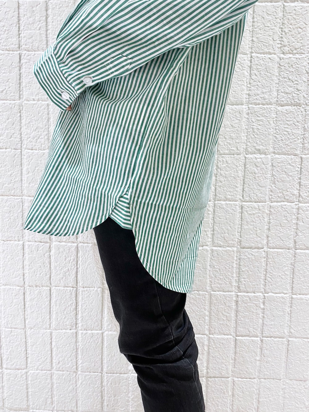 グリーン系のシャツ/ブラウス、ブラック系のTシャツ/カットソー、ブラック系のデニムパンツを着用したレディースの冬コーディネートの4枚目の写真