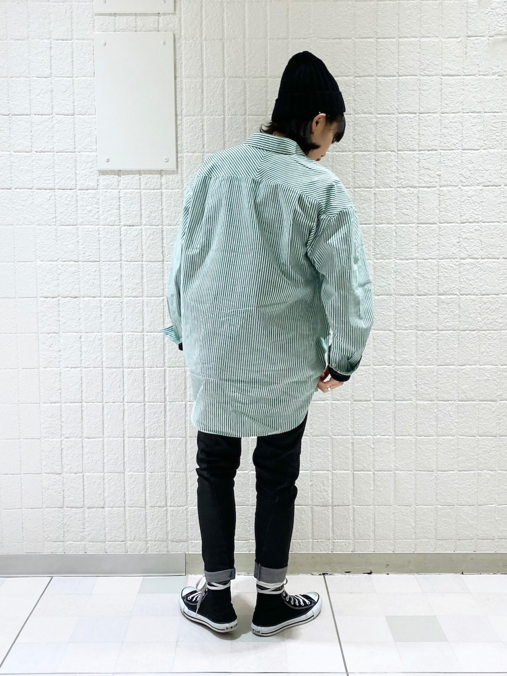 グリーン系のシャツ/ブラウス、ブラック系のTシャツ/カットソー、ブラック系のデニムパンツを着用したレディースの冬コーディネートの2枚目の写真