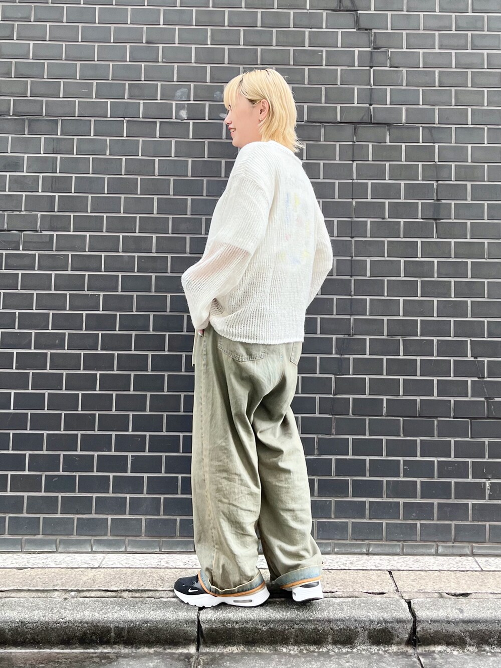 ホワイト系のニット/セーター、ホワイト系のTシャツ/カットソー、ブルー系のデニムパンツを着用したレディースの秋コーディネートの5枚目の写真