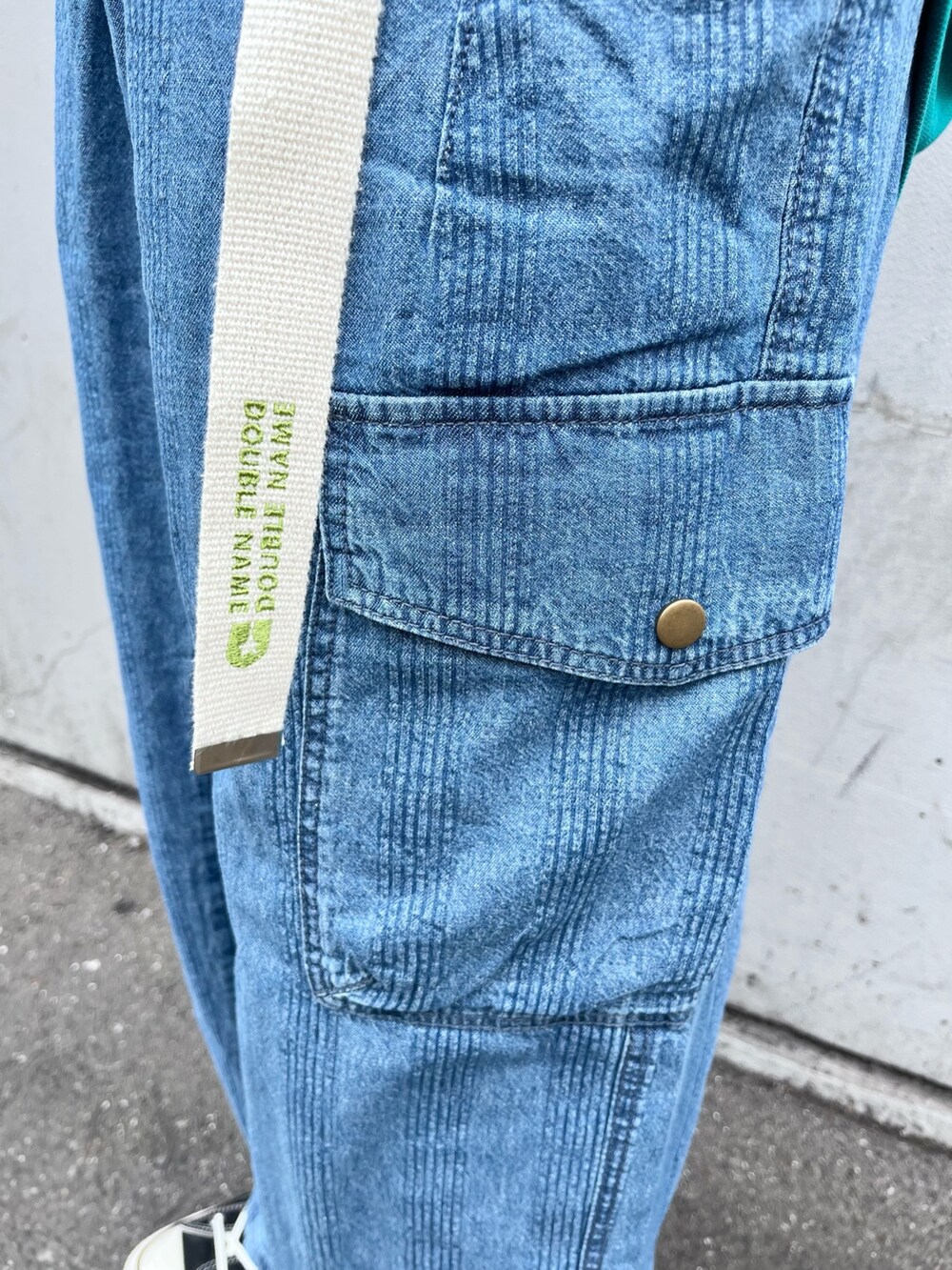 グリーン系のポロシャツ、ブルー系のデニムパンツ、ホワイト系のベルトを着用したレディースの春コーディネートの4枚目の写真