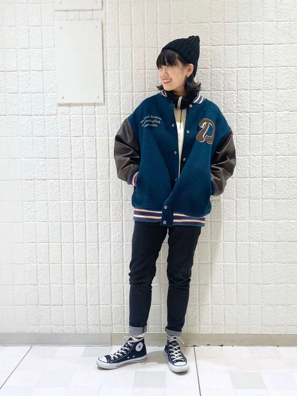 ブルー系のブルゾン、ブラック系のデニムパンツ、ブラック系のスニーカーを着用したレディースの冬コーディネートの2枚目の写真