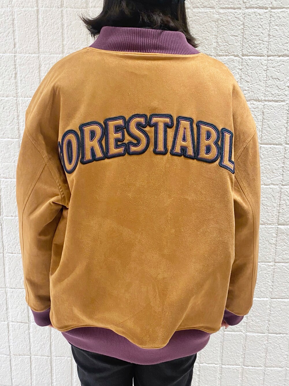 ブルー系のブルゾン、ブラック系のデニムパンツ、ブラック系のスニーカーを着用したレディースの冬コーディネートの5枚目の写真