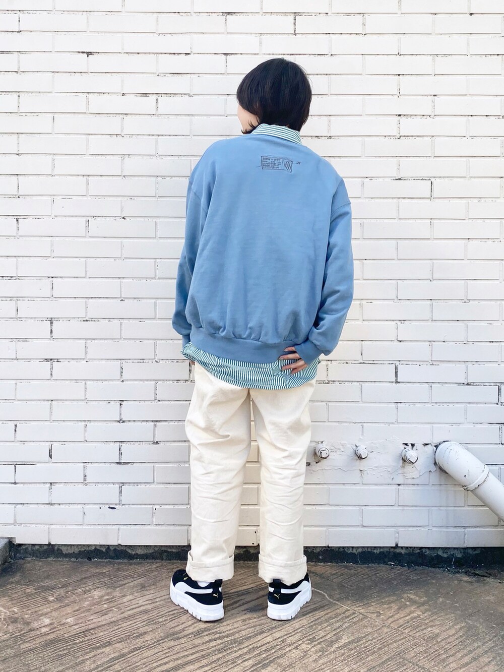 ホワイト系のデニムパンツ、グリーン系のシャツ/ブラウス、ブルー系のスウェットを着用したレディースの冬コーディネートの3枚目の写真