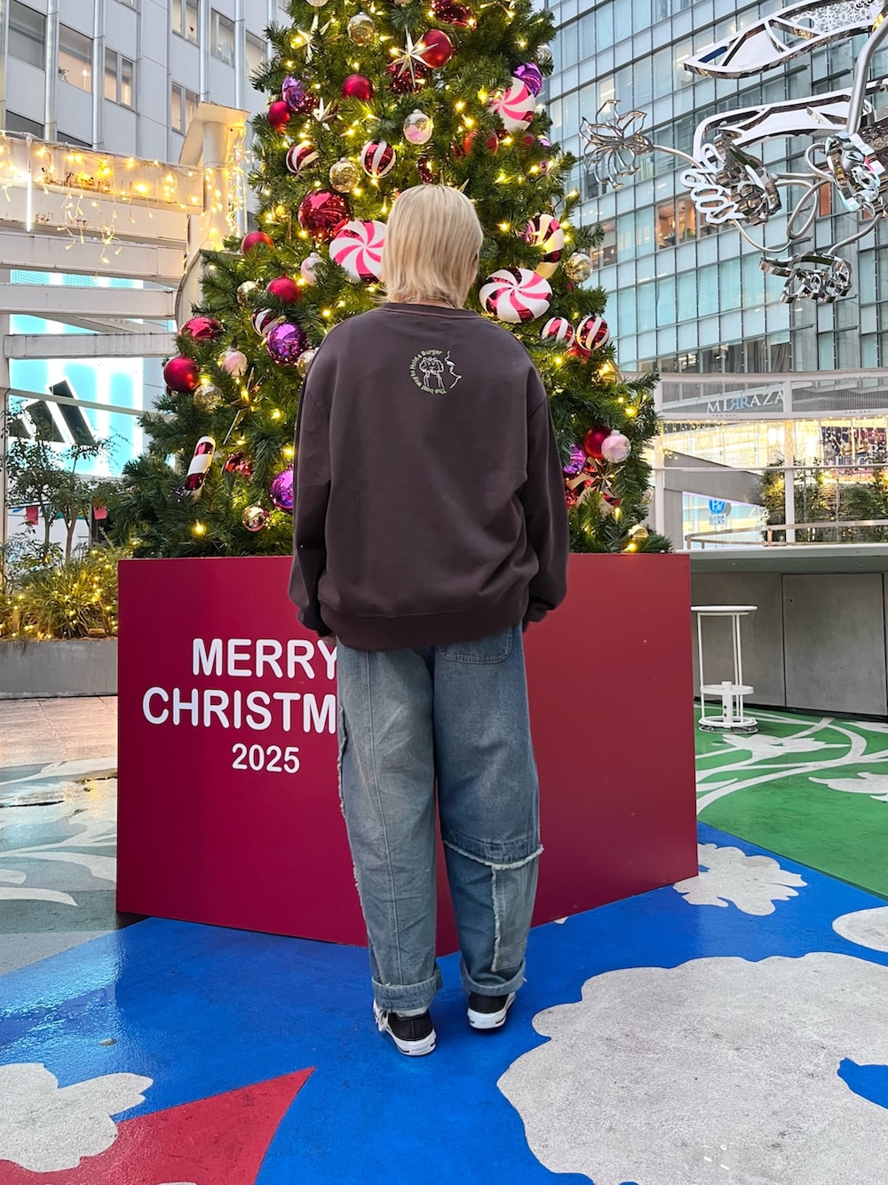 ブラック系のスウェット、ブルー系のデニムパンツ、ホワイト系のベルトを着用したレディースの冬コーディネートの3枚目の写真