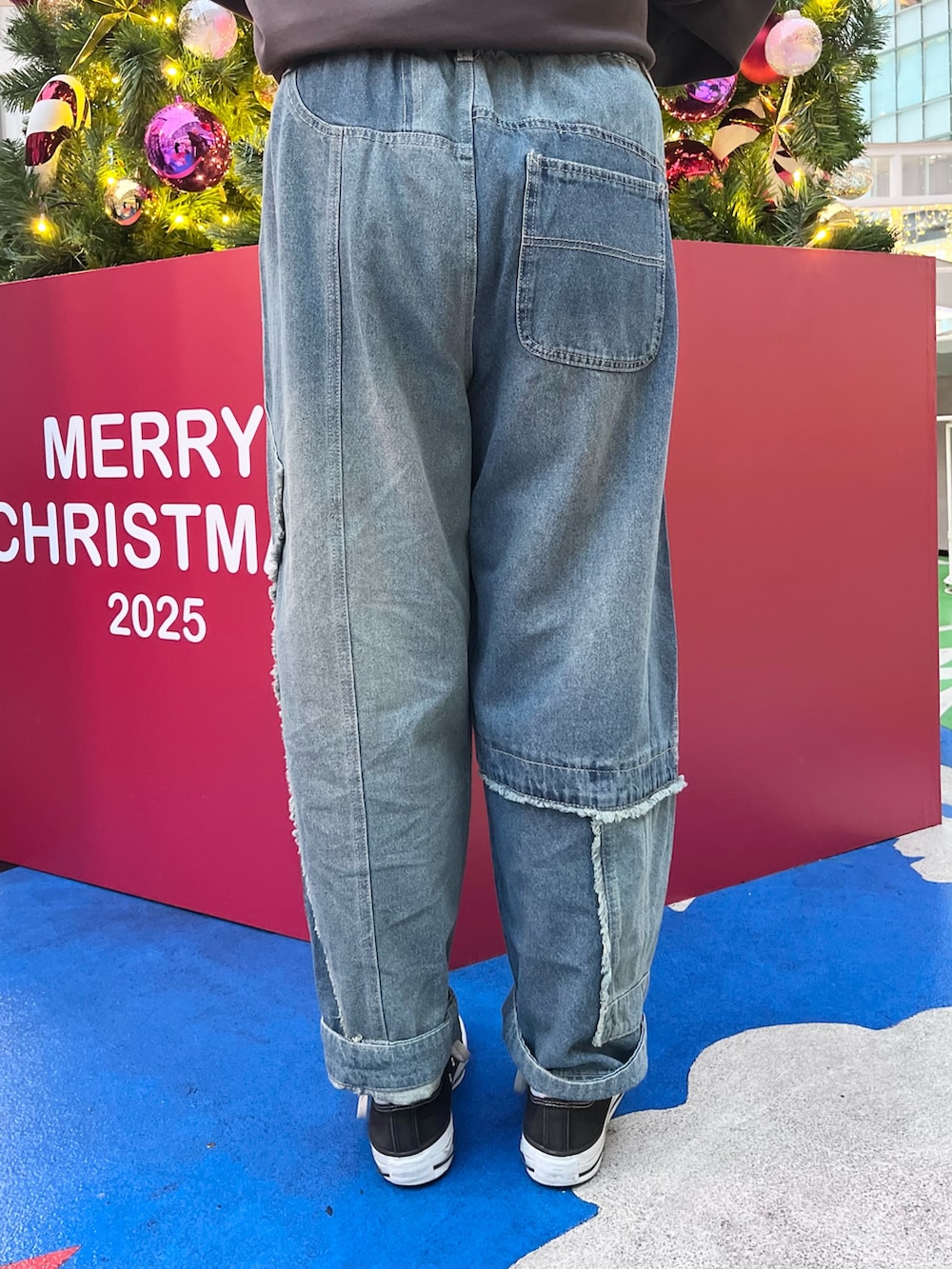 ブラック系のスウェット、ブルー系のデニムパンツ、ホワイト系のベルトを着用したレディースの冬コーディネートの8枚目の写真