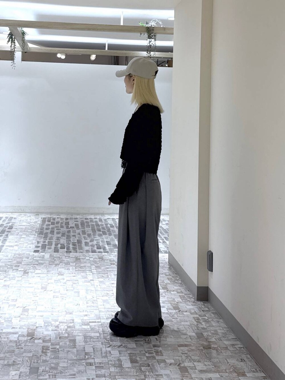 ブラック系のスニーカー、ブラック系のTシャツ/カットソー、グレー系のスラックスを着用したレディースの春コーディネートの4枚目の写真