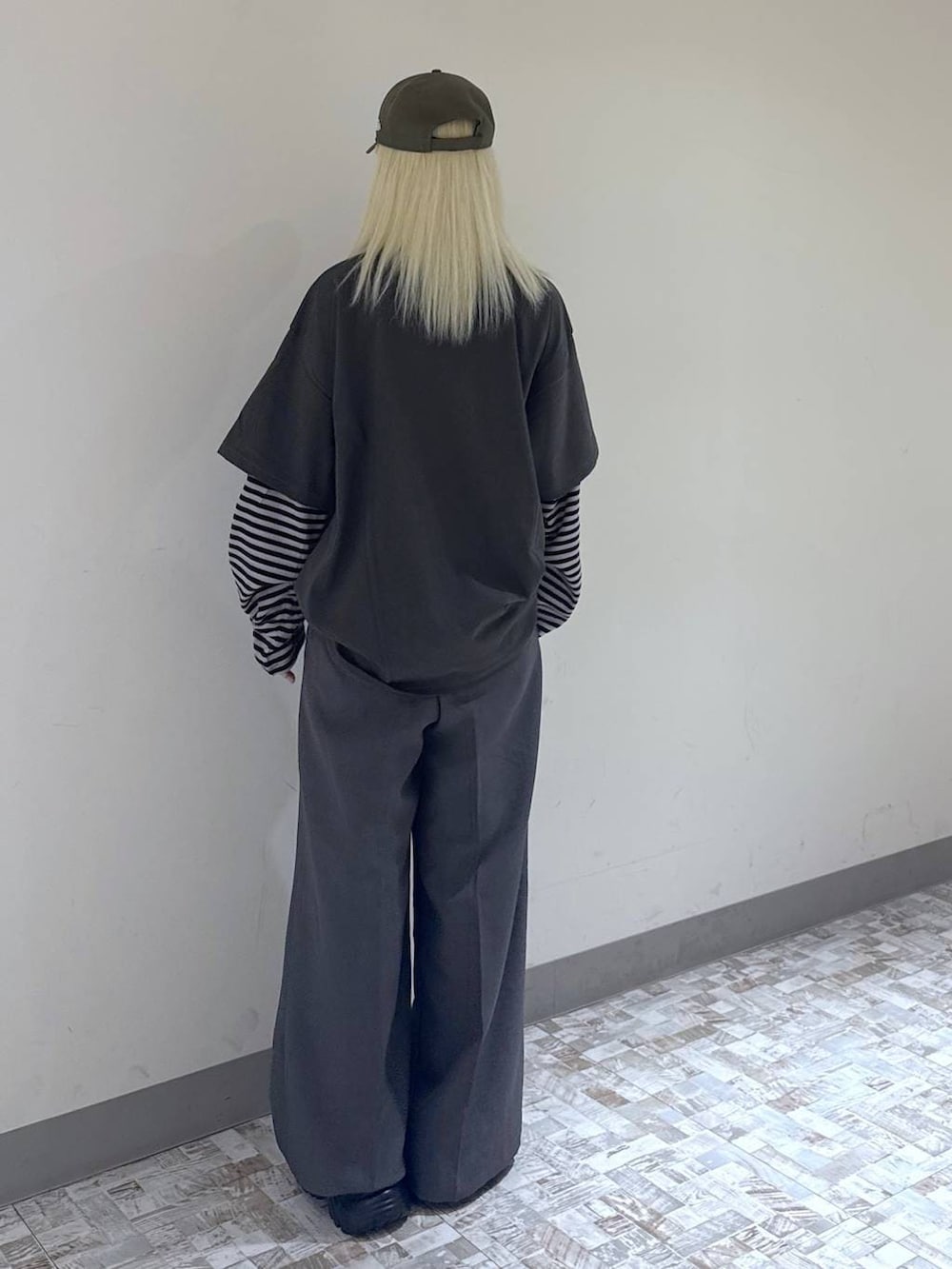 グレー系のスラックス、ブラック系のボストンバッグ、グリーン系のTシャツ/カットソーを着用したレディースの夏コーディネートの5枚目の写真