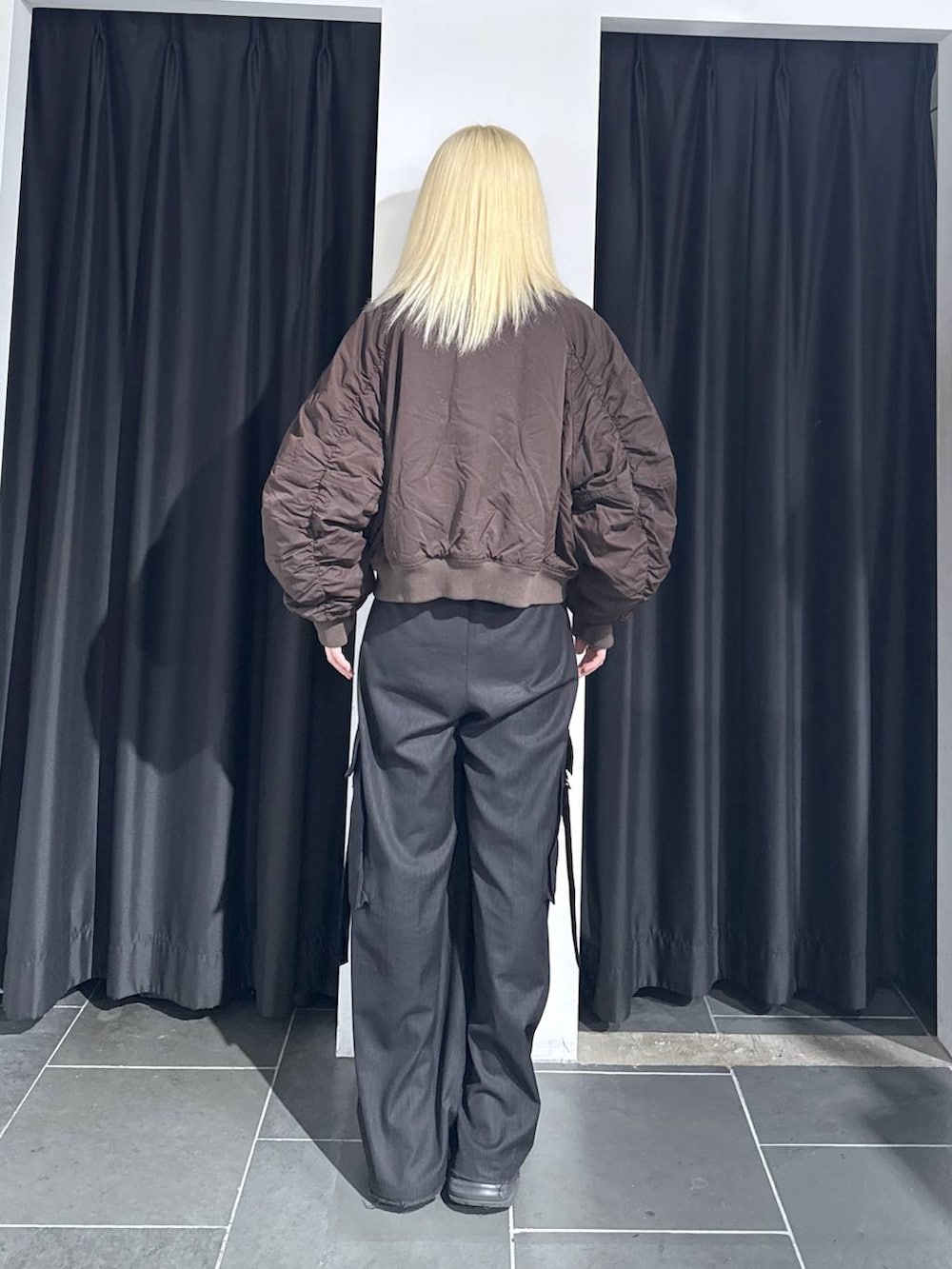 ブラック系のブーツ、ブラック系のスラックス、ブラウン系のブルゾンを着用したレディースの秋コーディネートの5枚目の写真