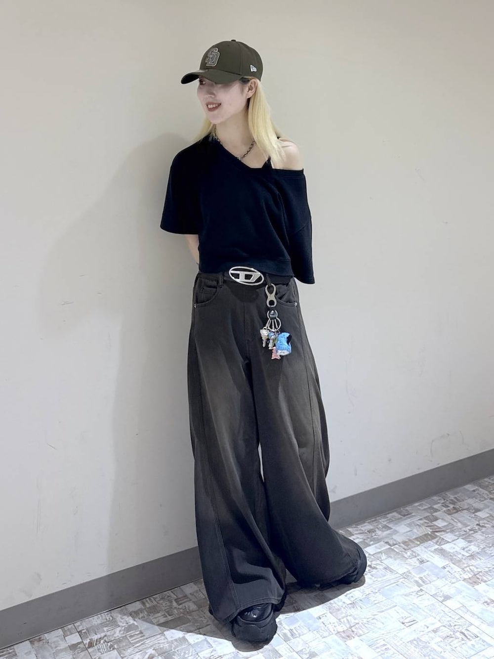 ブラウン系のデニムパンツ、ブラック系のスウェット、ブラック系のブーツを着用したレディースの夏コーディネートの3枚目の写真